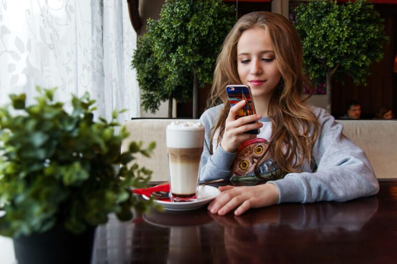 スマホをみながら話を聞く女性