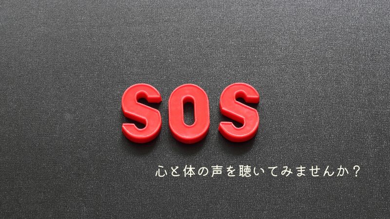 黒い背景に、「SOS」の形のブロックのようなものが置かれた画像。